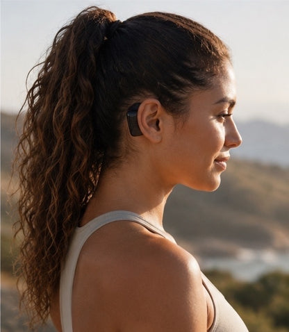 Woman outdoors wearing AWEAR behind the ear