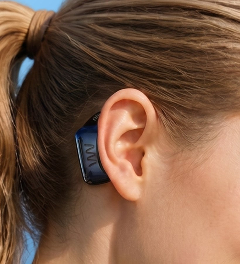Close-up of the AWEAR device resting behind a woman's ear